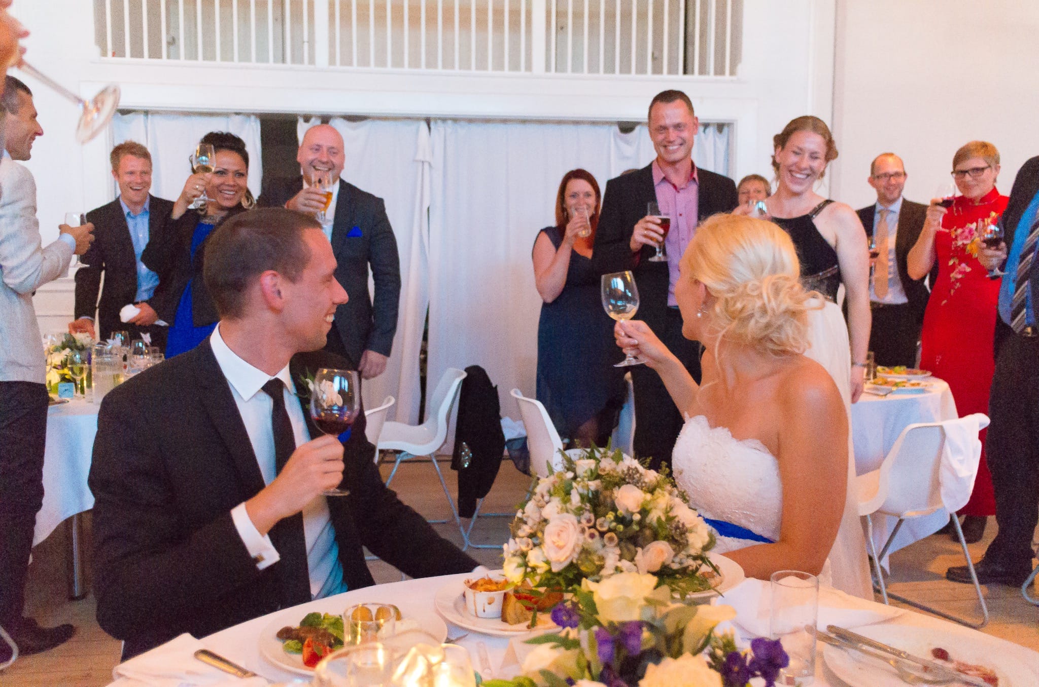 Couple raising a toast with guests at the reception